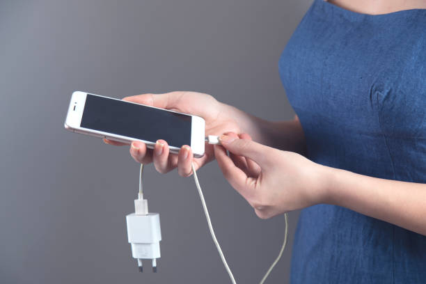 istock woman hand smart phone with USB 1219551171