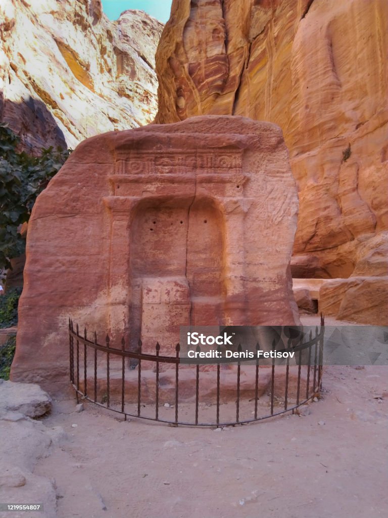 The small Rome temple in the narrow slot-canyon to the hidden city of Petra, Jordan The small Rome temple in the narrow slot-canyon that serves as the entrance passage to the hidden city of Petra, Jordan. This is an UNESCO World Heritage Site Ancient Stock Photo