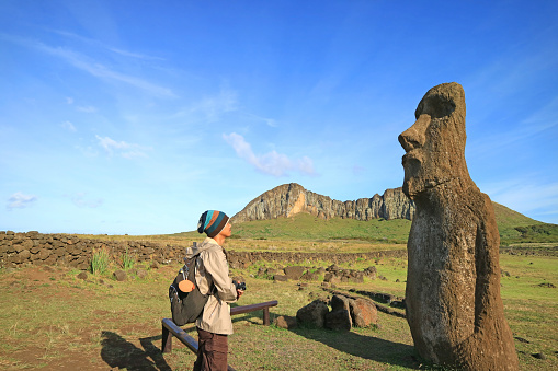 Traveler impressed by a Huge Moai Statue Ruins on Easter Island, Chile, South America
