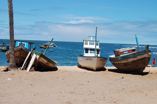 Salvador de Bahia, Brazil - August, 19, 2006: Three fishing boats on the sandy beach near Salvador de Bahia, Brazil