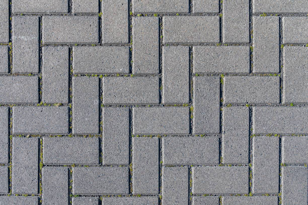 istock Concrete paving stones in grey during midday noon sunlight laid out in regular pattern texture 1219558451