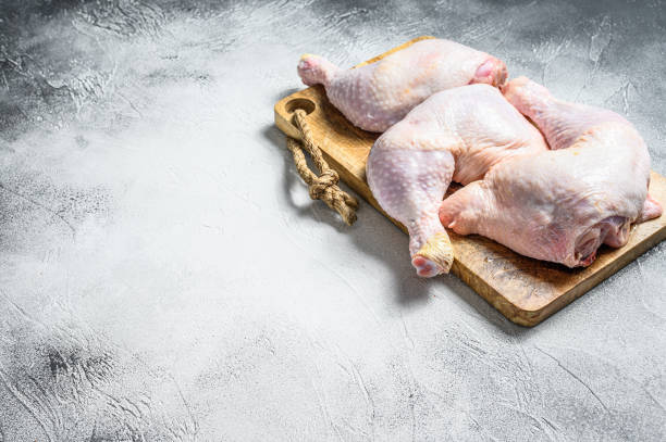 istock Raw chicken thighs on a chopping Board. Gray background. Top view. Copy space. 1219559644