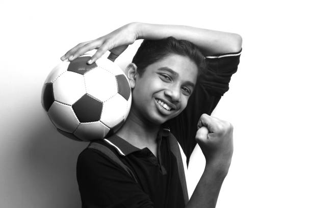 Energetic young boy holding a soccer ball