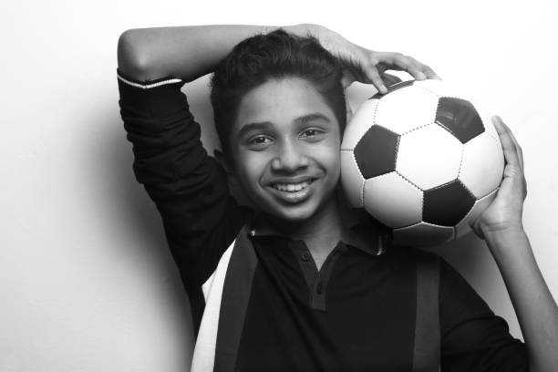 istock Energetic young boy holding a soccer ball 1219560946