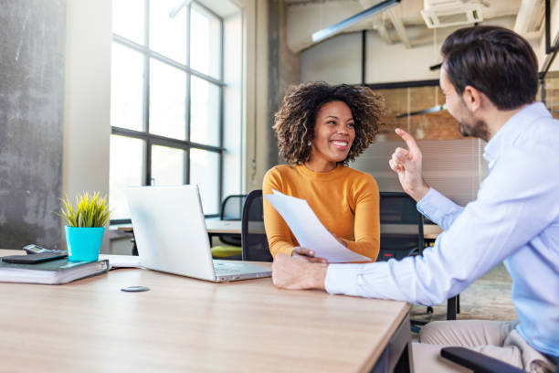 female manager broker consulting client in corporate office with laptop - laptop partnership looking communication imagens e fotografias de stock