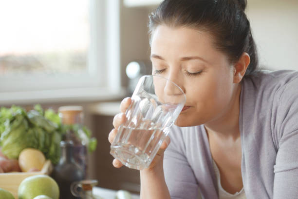 istock woman in the kitchen preparing food (drinking water) 1219561137