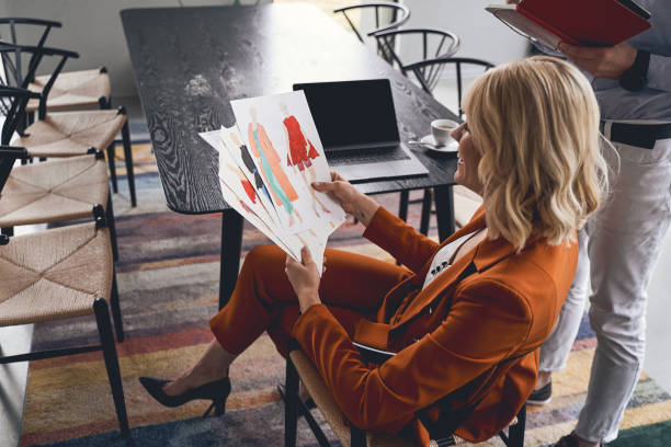 istock Cheerful woman holding sketches in her hands 1219562135