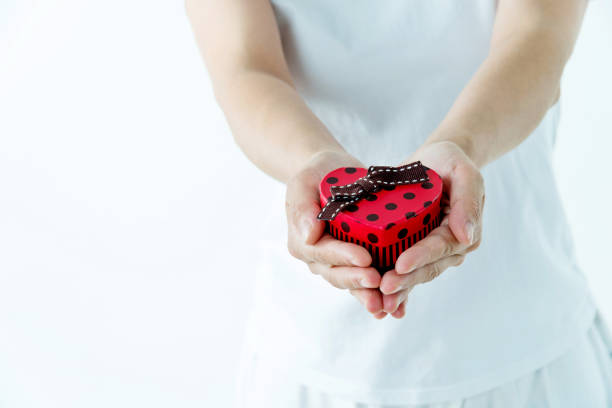 Woman hands holding a gift box on white background.