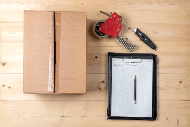 istock Packing box, notepad and pencil on a wooden table 1219564498