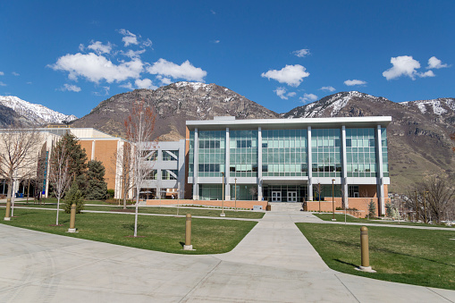 Provo, Utah, USA - April 7, 2020: This is a springtime shot of the BYU campus with hardly any students around.  The trees are in bloom and the grass green.  This view shows the Engineering Building with Y Mountain in the background.