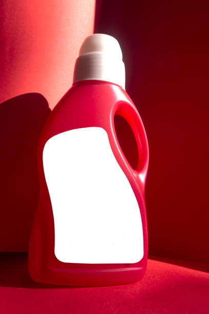 istock Red colored Detergent bottle on red colored paper background. 1219567990