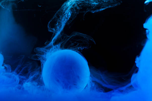 istock Glass ball with blue paint splash underwater and on a black backgorund 1219568184