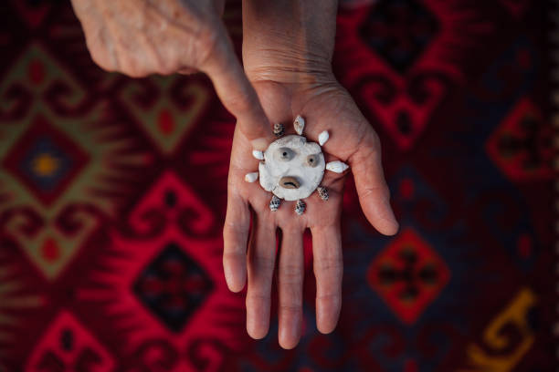 mujer mayor señalando roca de cerámica coronavirus con vieira - sensory perception shell using senses women fotografías e imágenes de stock