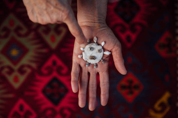 femme aîné pointant la roche de céramique de coronavirus avec le pétoncle - sensory perception shell using senses women photos et images de collection
