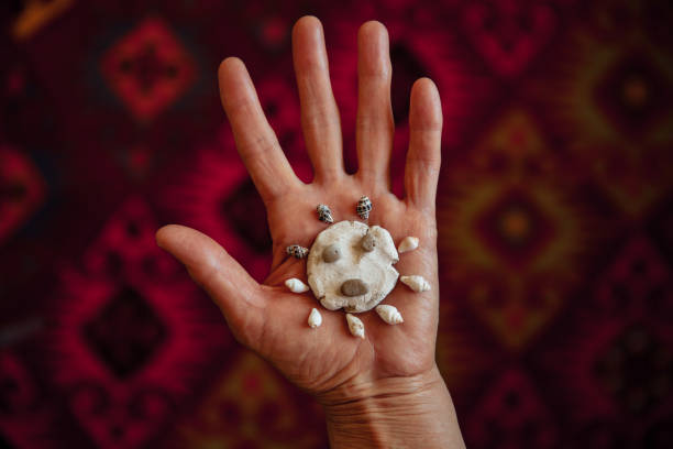 femme aîné retenant la roche de céramique de coronavirus avec le pétoncle - sensory perception shell using senses women photos et images de collection