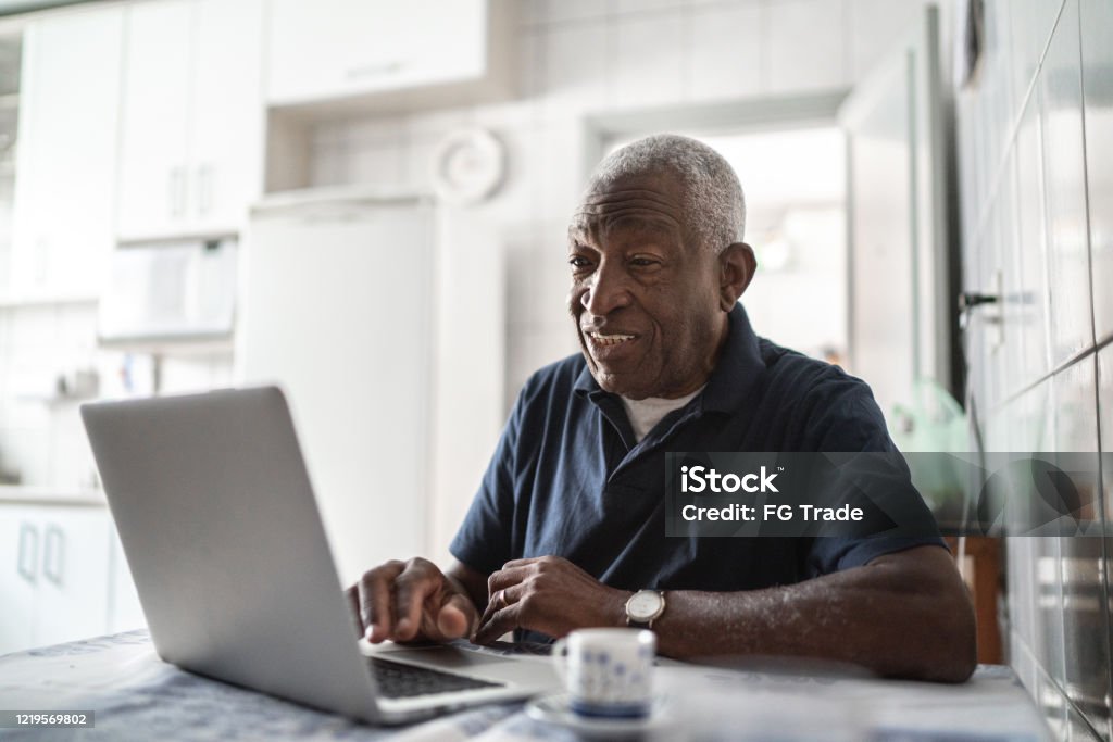 Senior man working at laptop at home Senior Adult Stock Photo