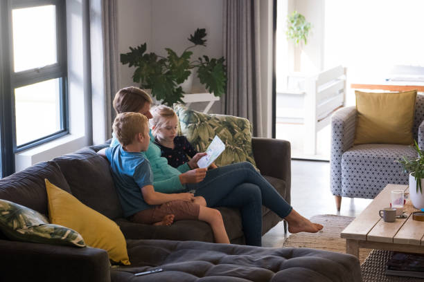 istock Mother reads a book to her kids on the sofa 1219574382
