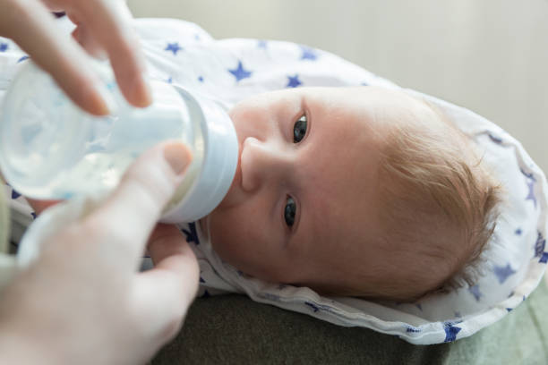 istock Feeding a small newborn baby formula from a bottle. Artificial 1219576151
