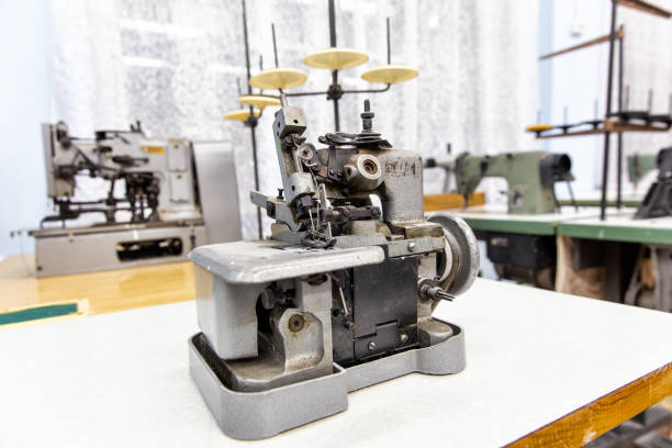 istock Closeup details on sewing machine overlock. Workplace seamstress. Tailoring industry 1219576416