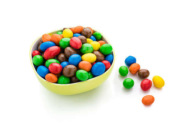 istock Multi colored chocolate candies in a bowl isolated on white background 1219577269
