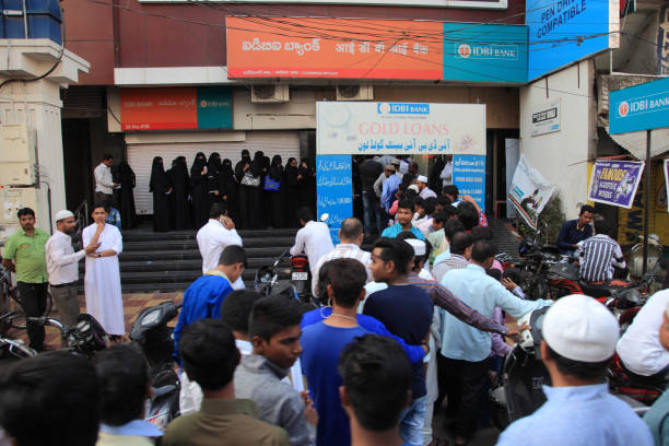 People stand in long queue outside banks during the demonetisation of Indian currency Hyderabad, India - November11,2016: Unidentified people stand in long queue outside banks to exchange the banned 500 and 1000 currency notes in Hyderabad, India. government large currency finance stock pictures, royalty-free photos & images