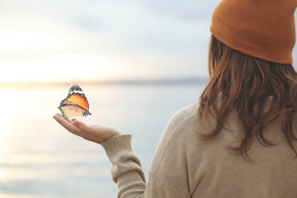 istock delicate moment  between a butterfly and a woman 1219580181