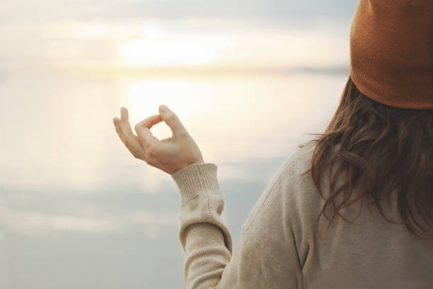 meditative frau macht entspannungsübungen vor dem meer - nature writing women ideas stock-fotos und bilder