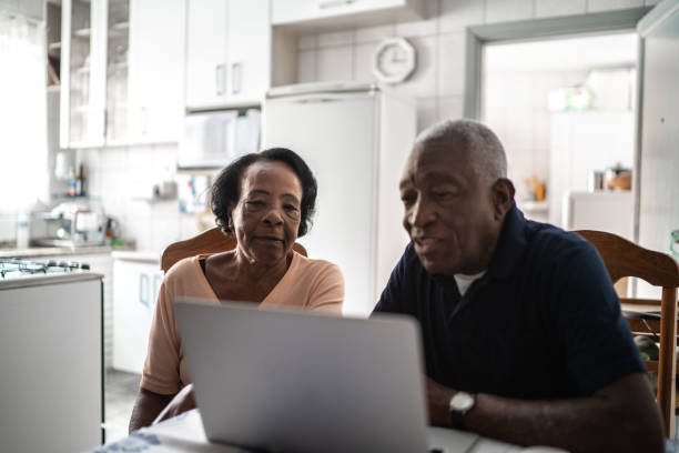 istock Senior couple using laptop at kitchen 1219580420