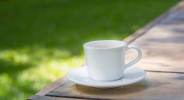istock white coffee cup place on plank wood table in morning,Soft light. 1219585897