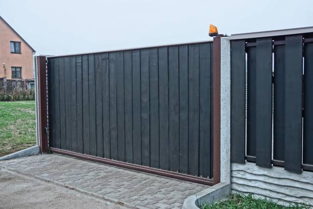 istock gray black private gate and wooden plank fence 1219588146