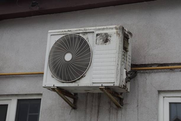 istock one white dirty air conditioning fan hanging on a gray wall 1219588183