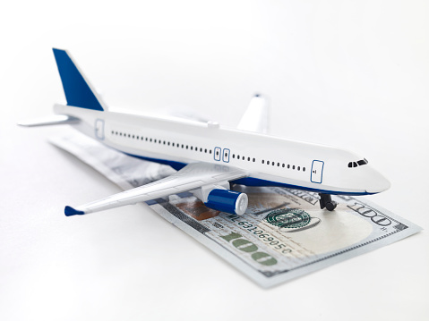 Toy plane on a desktop with a pile of 100 dollar bills