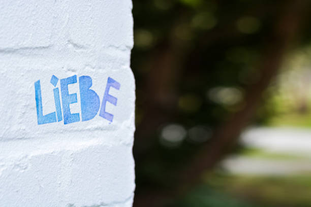 istock Text love in German on a white brick wall with empty space on the right 1219589788