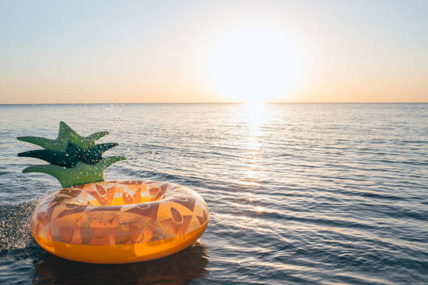 inflatable pineapple floating in sea. close up shot of rubber ring with space for text. - beach nautical vessel party clothing imagens e fotografias de stock