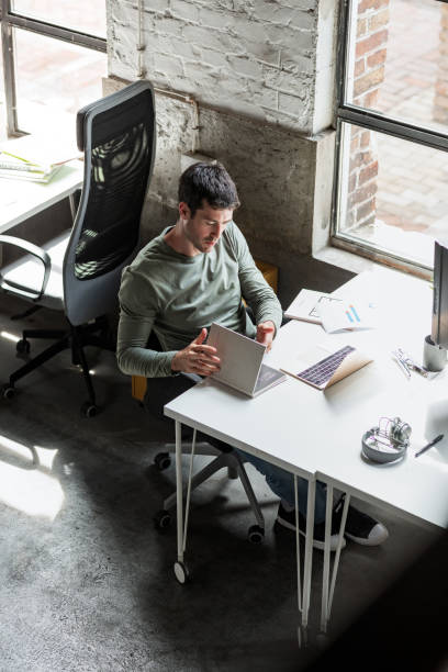 istock Casual Young Businessman Working at an Open Space Loft Office 1219591589