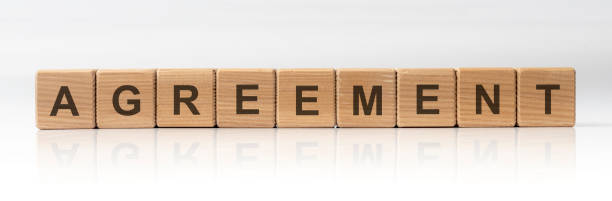 istock AGREEMENT word on wooden cubes on white glossy background 1219592517