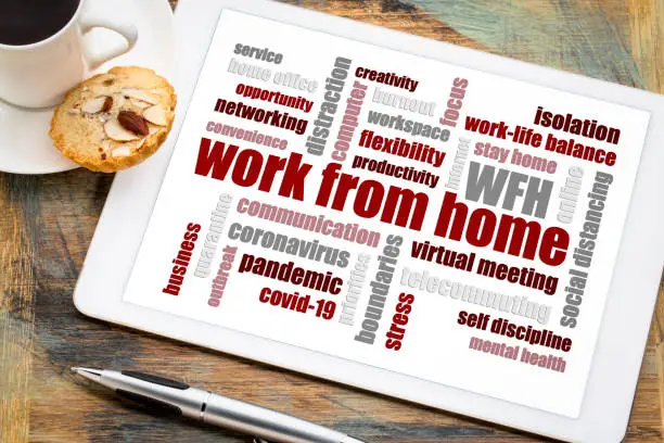 work from home word cloud on a digital tablet with a cup of coffee, social distancing, self quarantine and stay-at-home order during covid-19 coronavirus pandemic