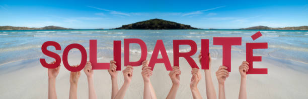 istock People Hands Holding Word Solidarite Means Solidarity, Ocean Background 1219592891