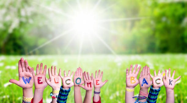 istock Children Hands Building Word Welcome Back, Grass Meadow 1219594154