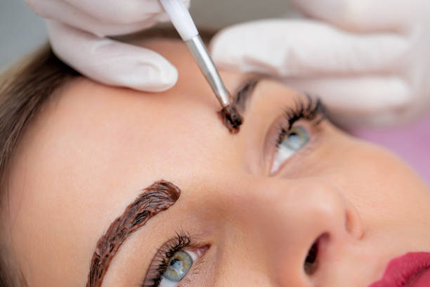 photo en gros plan de beautician applying dye on woman’s eyebrows - photo stock - colorant capillaire photos et images de collection