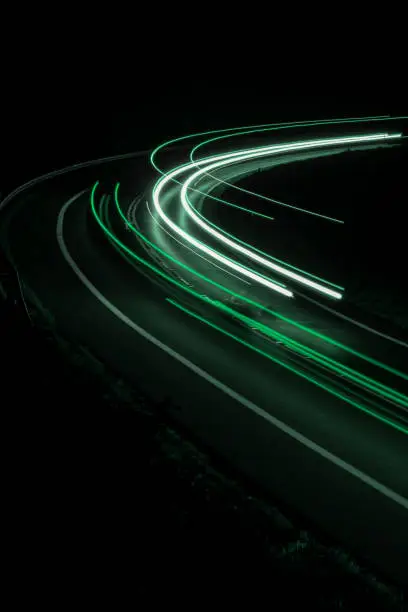 Photo of green car lights at night. long exposure