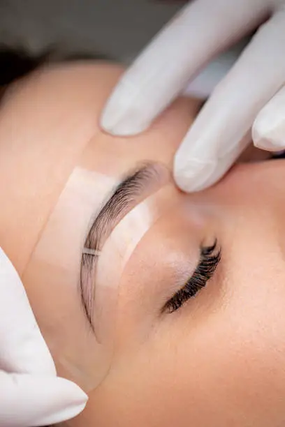 Beautician Using Transparent Stencil to Perfectly Shape Customer's Eyebrows