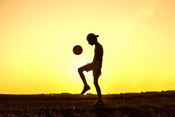 istock Boy playing with ball in nature in hot evening 1219596747