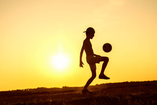 istock Boy playing with ball in nature in hot evening 1219596838