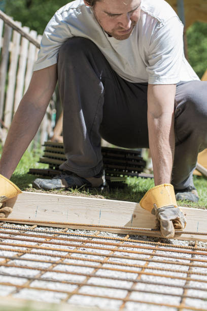 istock Man placing steel bars net in a hole as foundation 1219600500