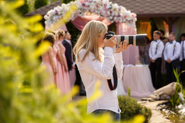 de fotograaf van het huwelijk met een professionele camera die bij een huwelijksceremonie werkt - fotograaf stockfoto's en -beelden