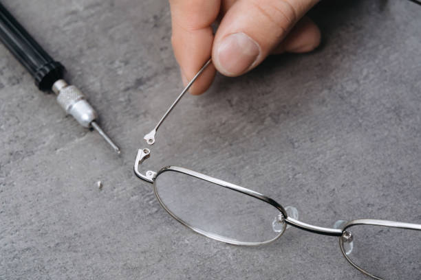 istock Man optometrist is setting temple of glasses 1219605228