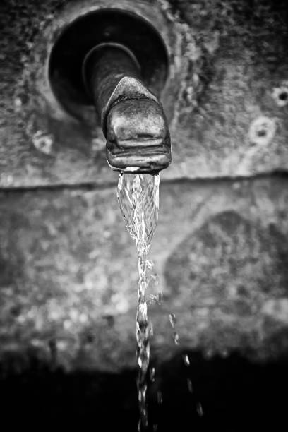 Pure fresh water waterfall in forest in the mountains. Old fontain close up. Selective focus