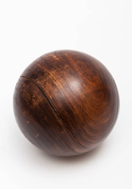 male hand holding a pair of wooden Chinese medicine balls against textured paper