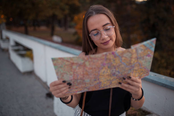 istock Young woman looking at city map in park 1219610028